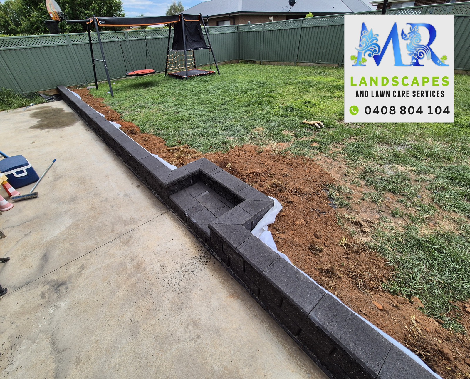 A retaining wall and landscaped yard by MR Landscapes