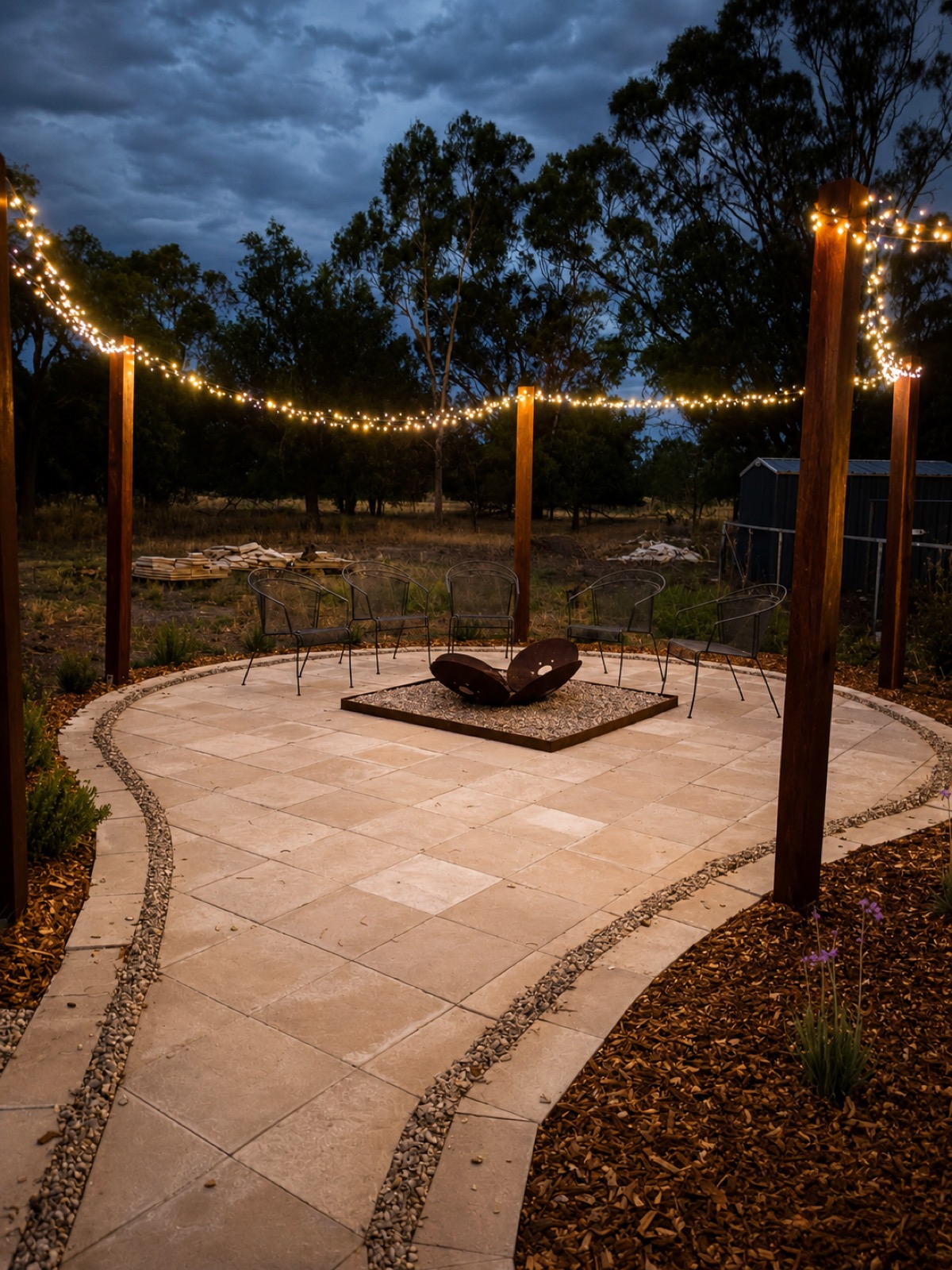 A firepit area with fairy lights and paving built by MR Landscapes near Dubbo