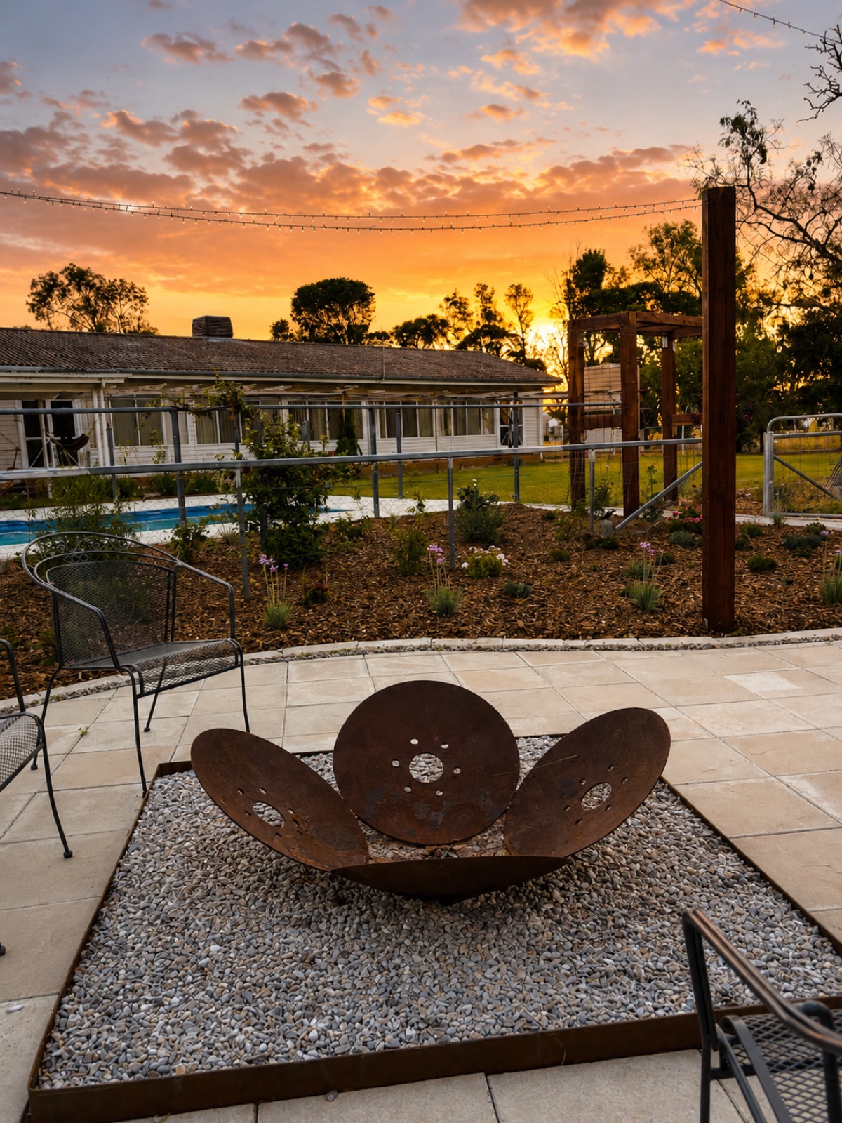 A steel firepit and paved area at sunset built by MR Landscapes in Dubbo