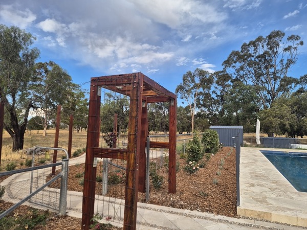 Feature archways beside a pool built by MR Landscapes