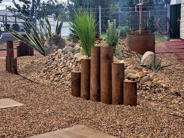 A designed garden with timber feature columns by MR Landscapes