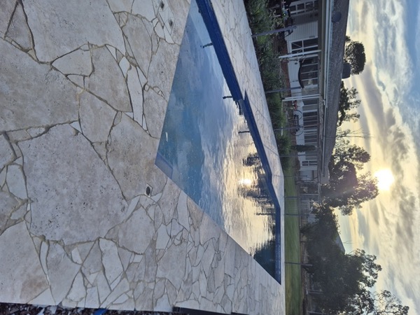 A pool with crazy-paving surround by MR Landscapes