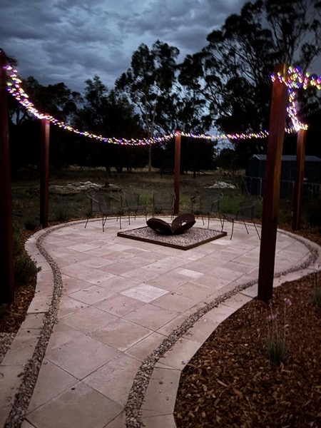 A firepit area with fairy lights by MR Landscapes