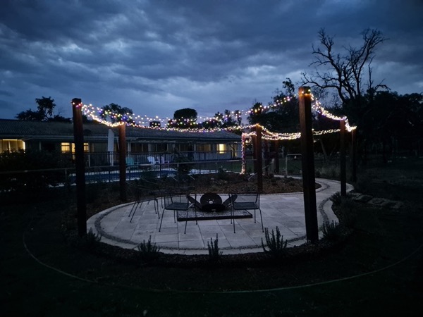 A firepit area lit at dusk by MR Landscapes