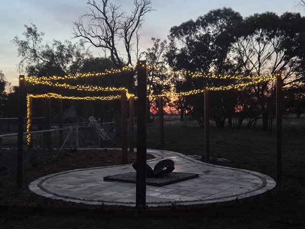 A firepit area with fairy lights at dusk by MR Landscapes