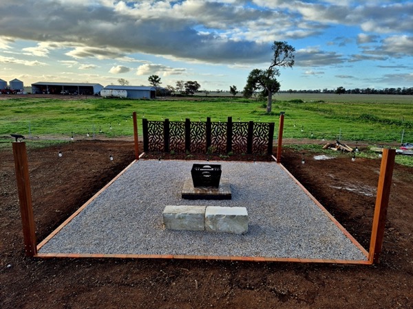 A firepit feature in a landscaped yard by MR Landscapes